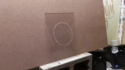 Before laying down any gold. Tape your design to the back of the glass, and use it as a guide to know where to apply the gold. Notice, I have a white circle drawn. This circle was traced with a grease pencil, then the sketch was removed. If you traced over the area with a grease pencil, make sure to flip the glass over so the grease pencil is on the opposite side from where you will be applying the gold. Now, Take a Water Size Brush, dip it in the Water Size (glue) and flood the area of glass where you will be applying the gold. Next, create a static charge by rubbing the Gilders Tip Brush on your hair, then open up your packet of gold to reveal a sheet and place the Gilders Tip Brush on top of the gold. The static charge should pick up the gold, and now the gold can be transfered from the gold packet to the glass. When laying down multiple sheets of gold, it is desirable to overlap the sheets by maybe around a quarter inch. 