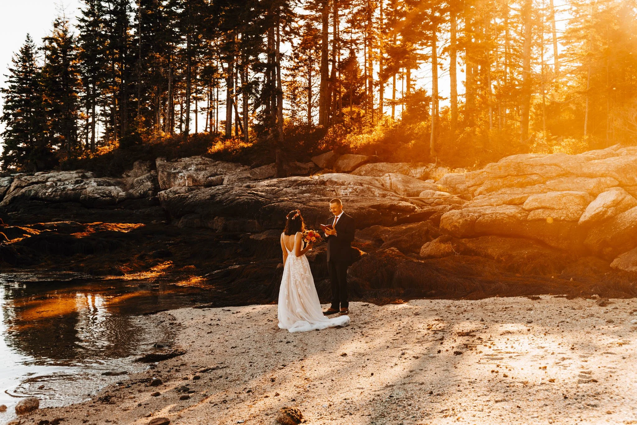 Private vows on an empty Maine beach, low sun burning through the spruce and reflecting in the tide pool
