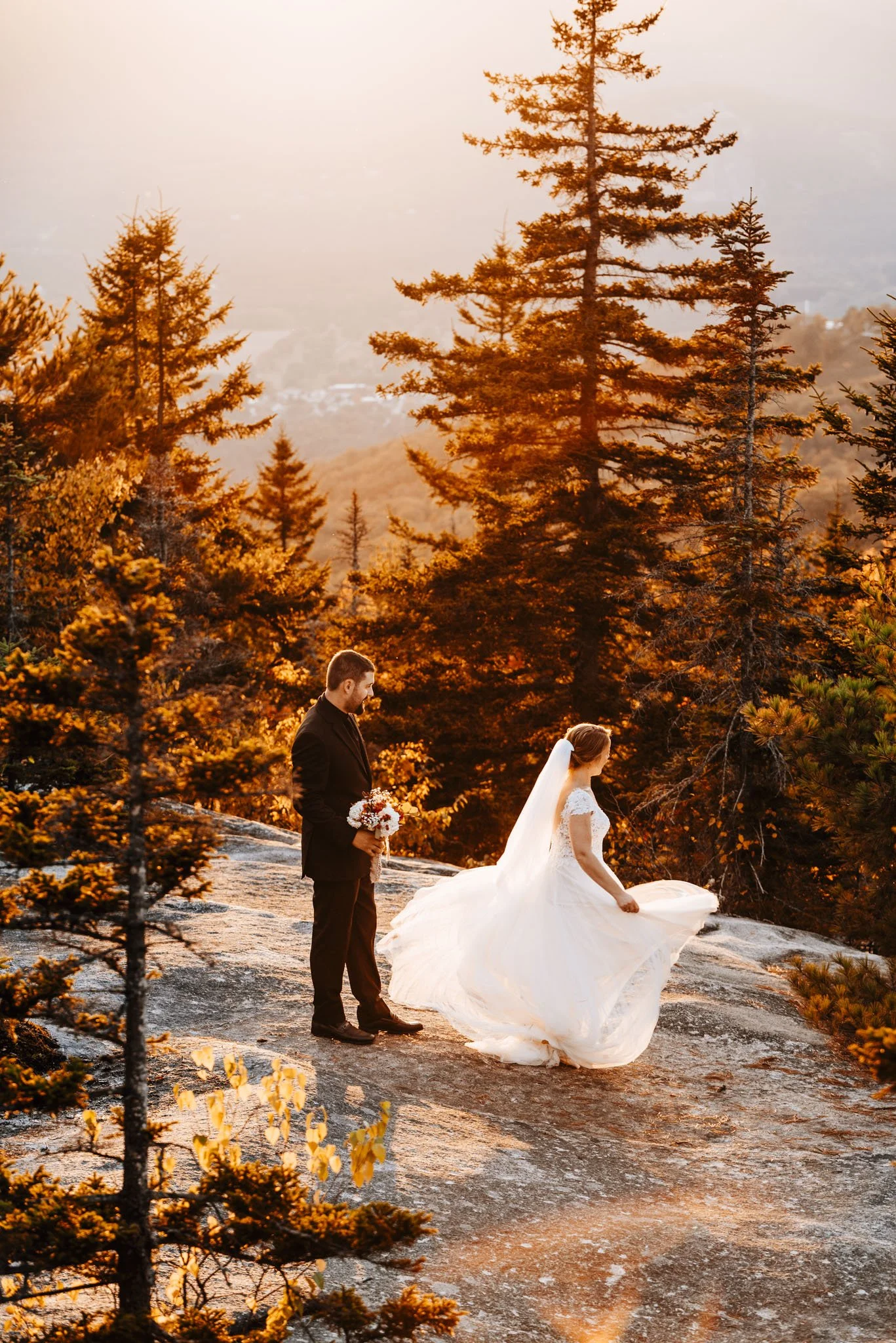 Bride's ballgown skirt sweeping across the granite summit of Black Cap Mountain, surrounded by golden spruce
