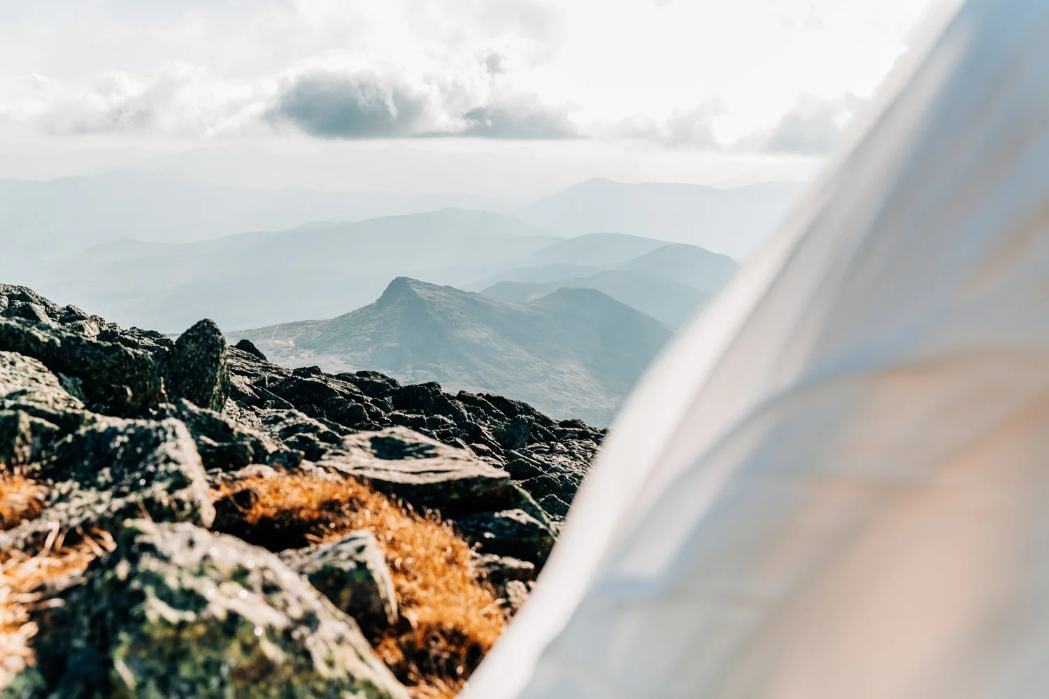 A wedding veil in the foreground with layered White Mountain ridgelines fading into haze behind it
