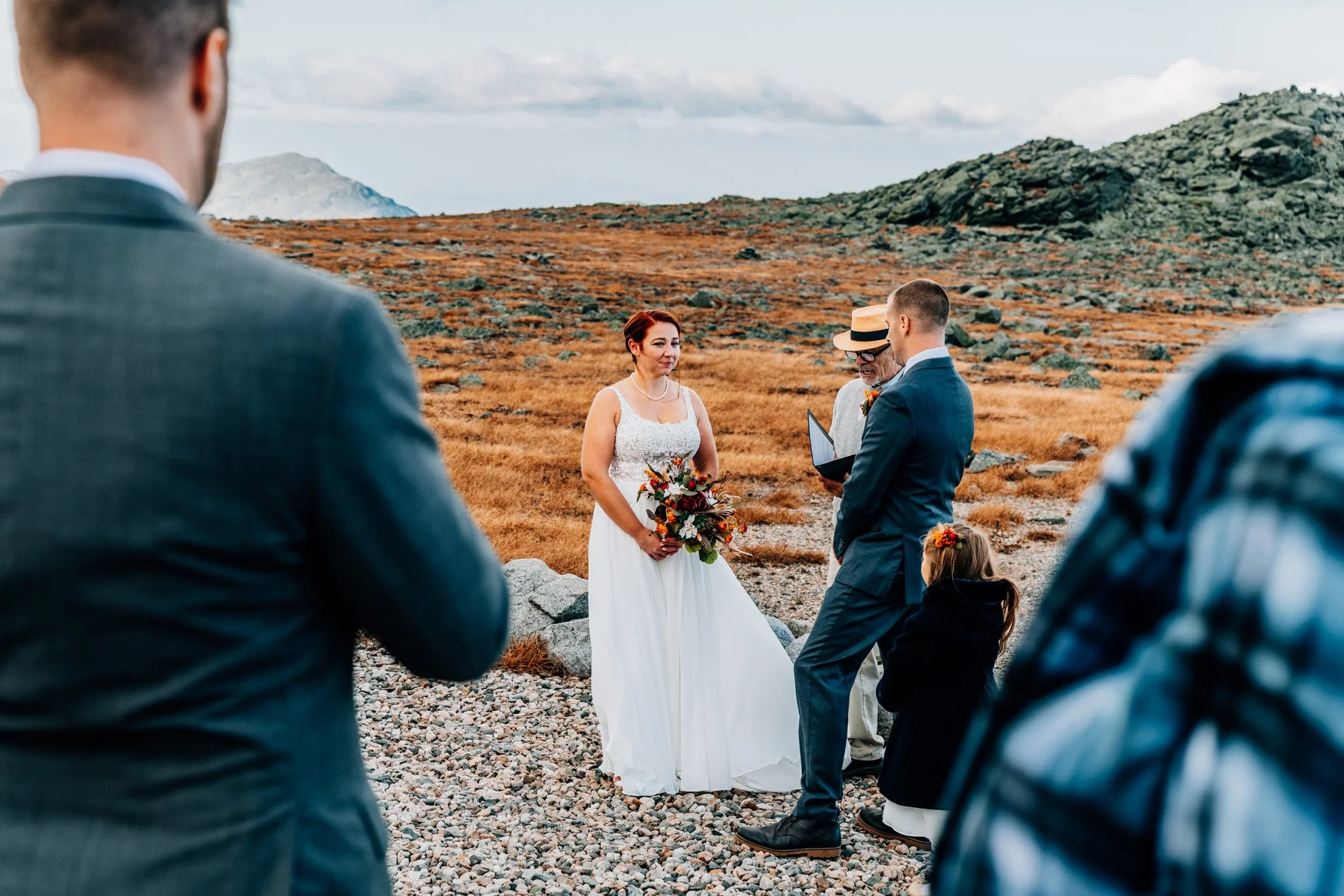 Ceremony on the Mount Washington Auto Road seen between guests, alpine tundra stretching out to the ridges