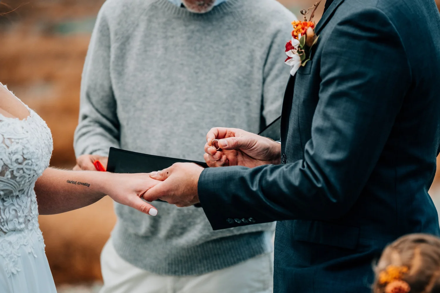 Close-up of the ring exchange during a Mount Washington summit wedding ceremony