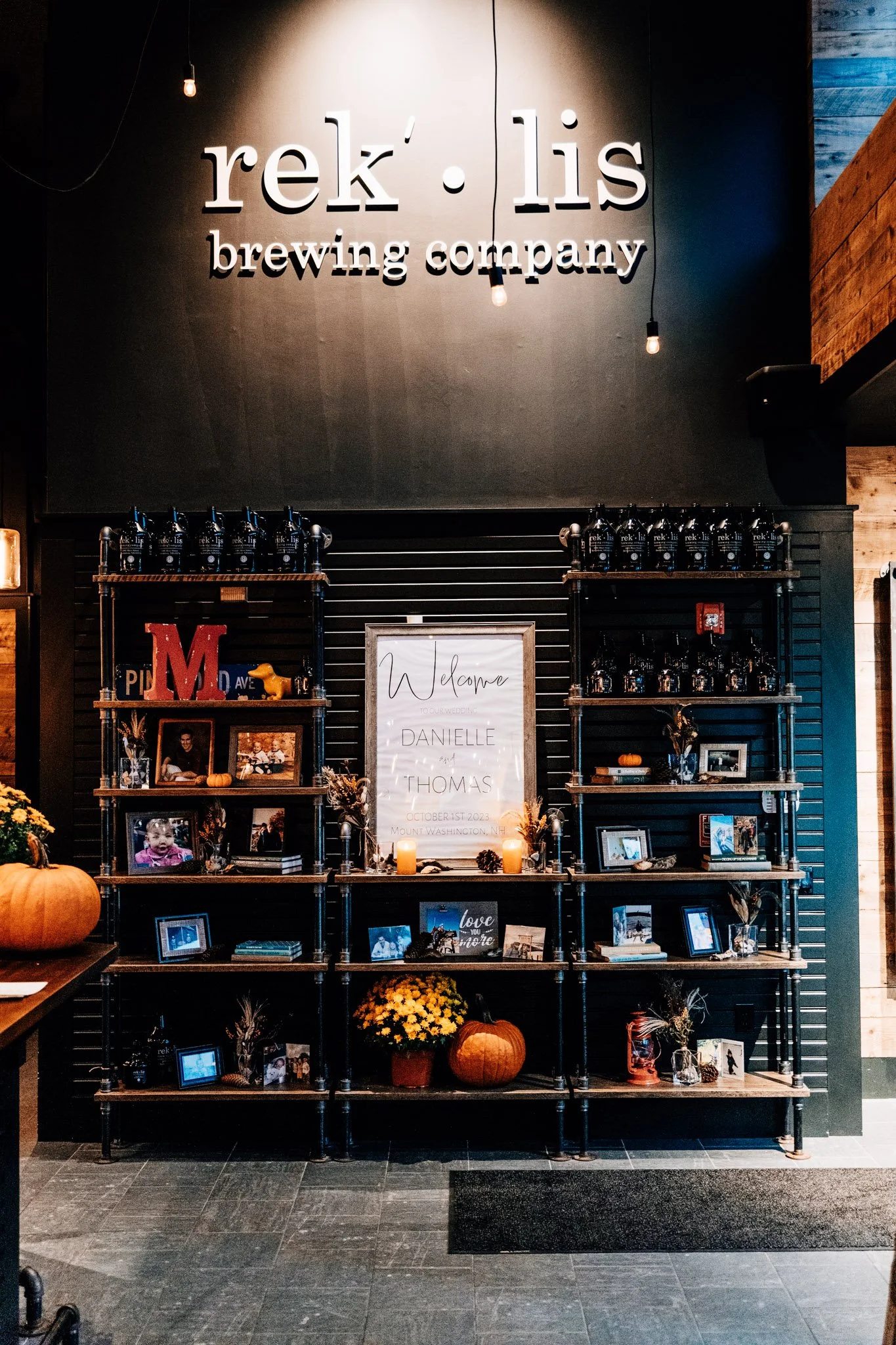 Welcome sign and framed photos for Danielle and Thomas at their Rek'lis Brewing Company reception in Bethlehem, New Hampshire