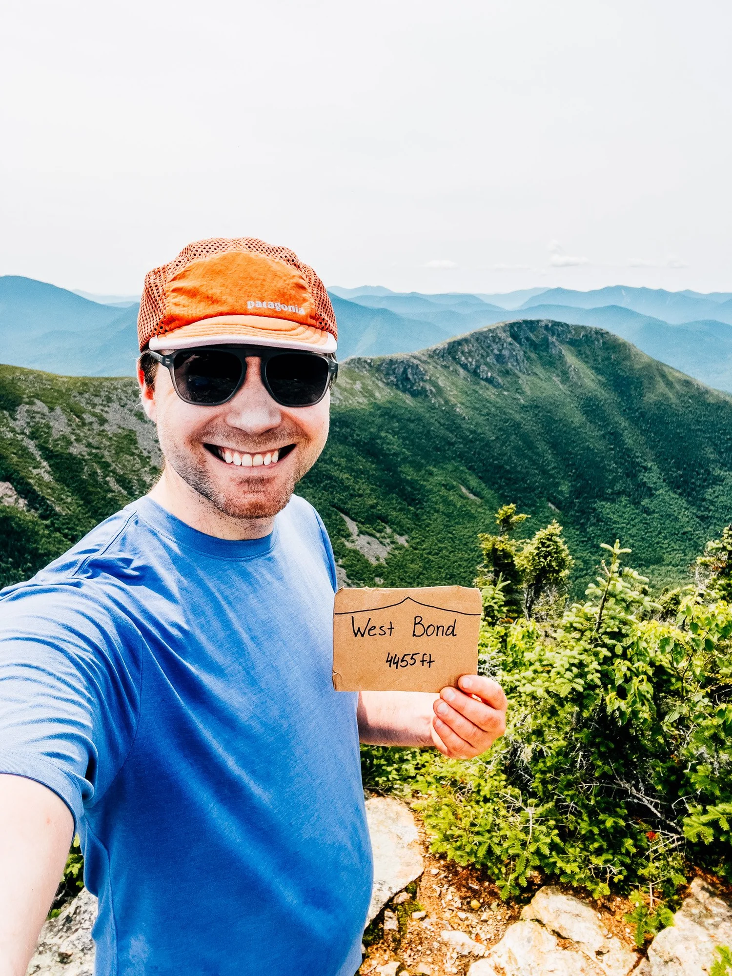 West Bond summit selfie holding the summit sign