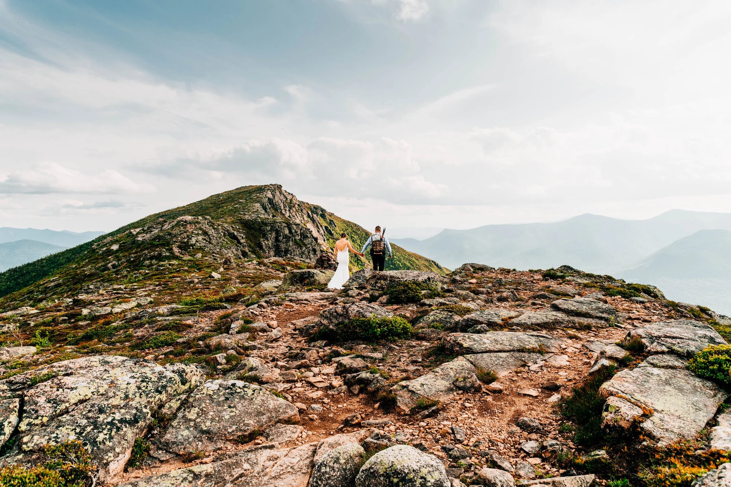 Mountain elopement couple standing on a rocky summit in the White Mountains of New Hampshire