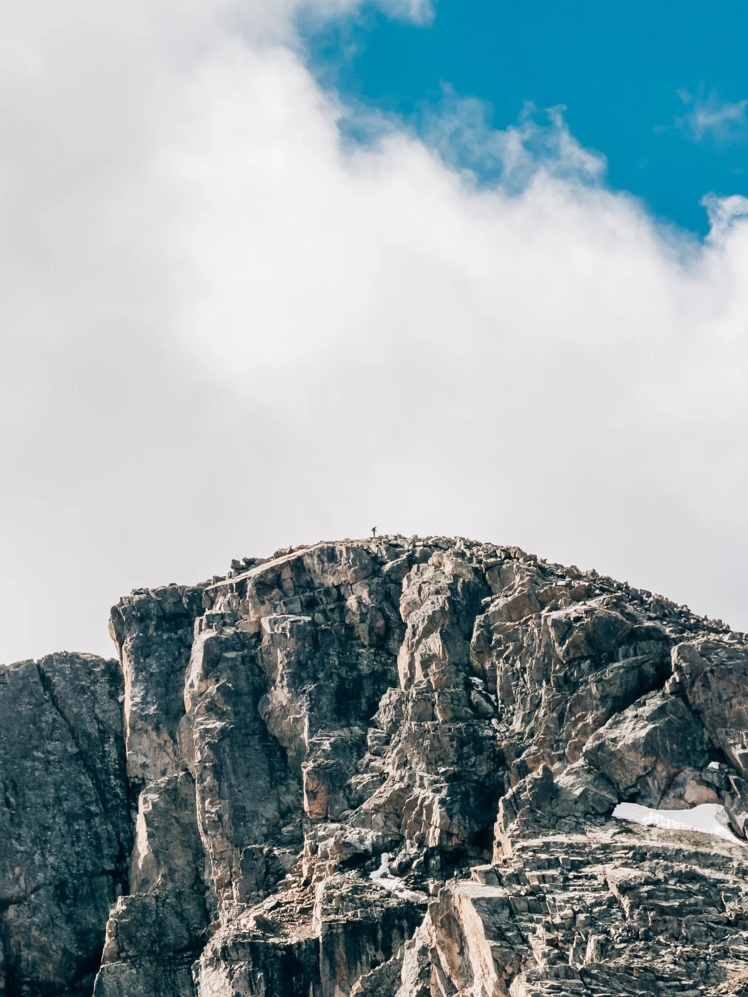 A tiny figure on the summit of Mount of the Holy Cross seen from far below on the ridge