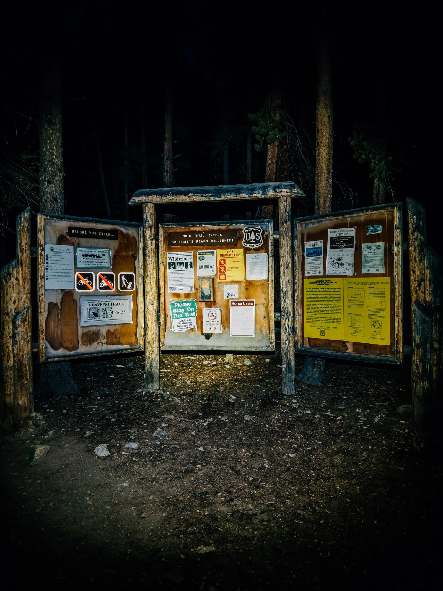 North Cottonwood Trailhead board lit by a headlamp before dawn, Collegiate Peaks