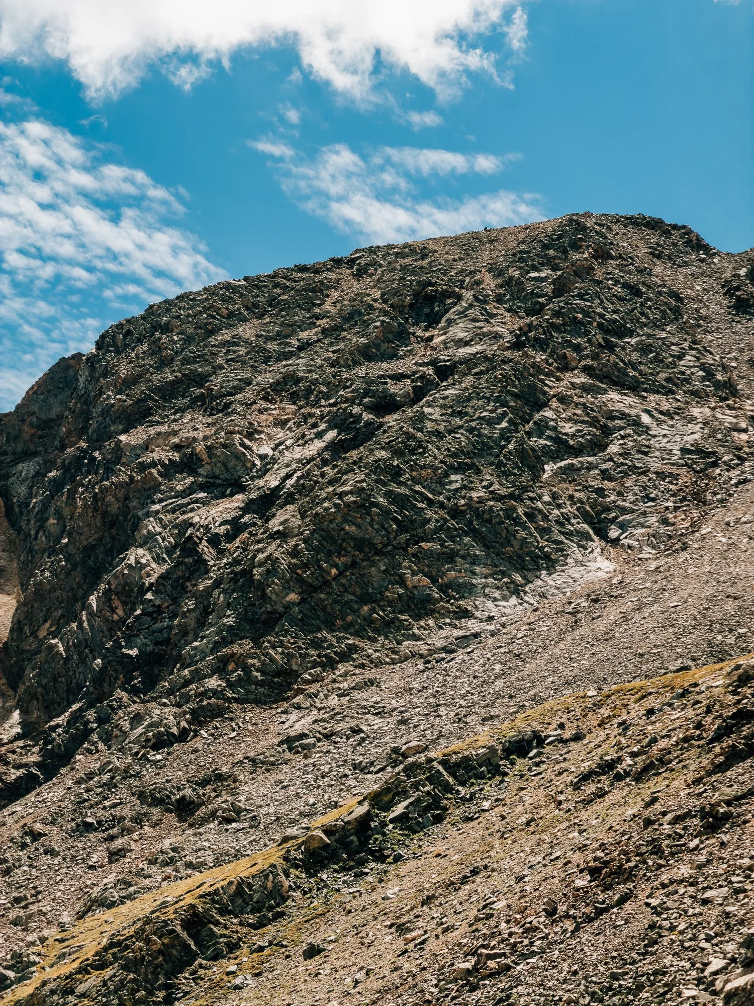 Zoomed view of dark, layered rock slopes high on Missouri Mountain above the upper basin