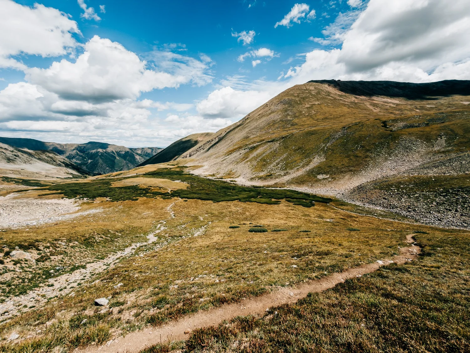 Trail climbing out of the upper Missouri Gulch basin, looking back over tundra, tarns and distant peaks