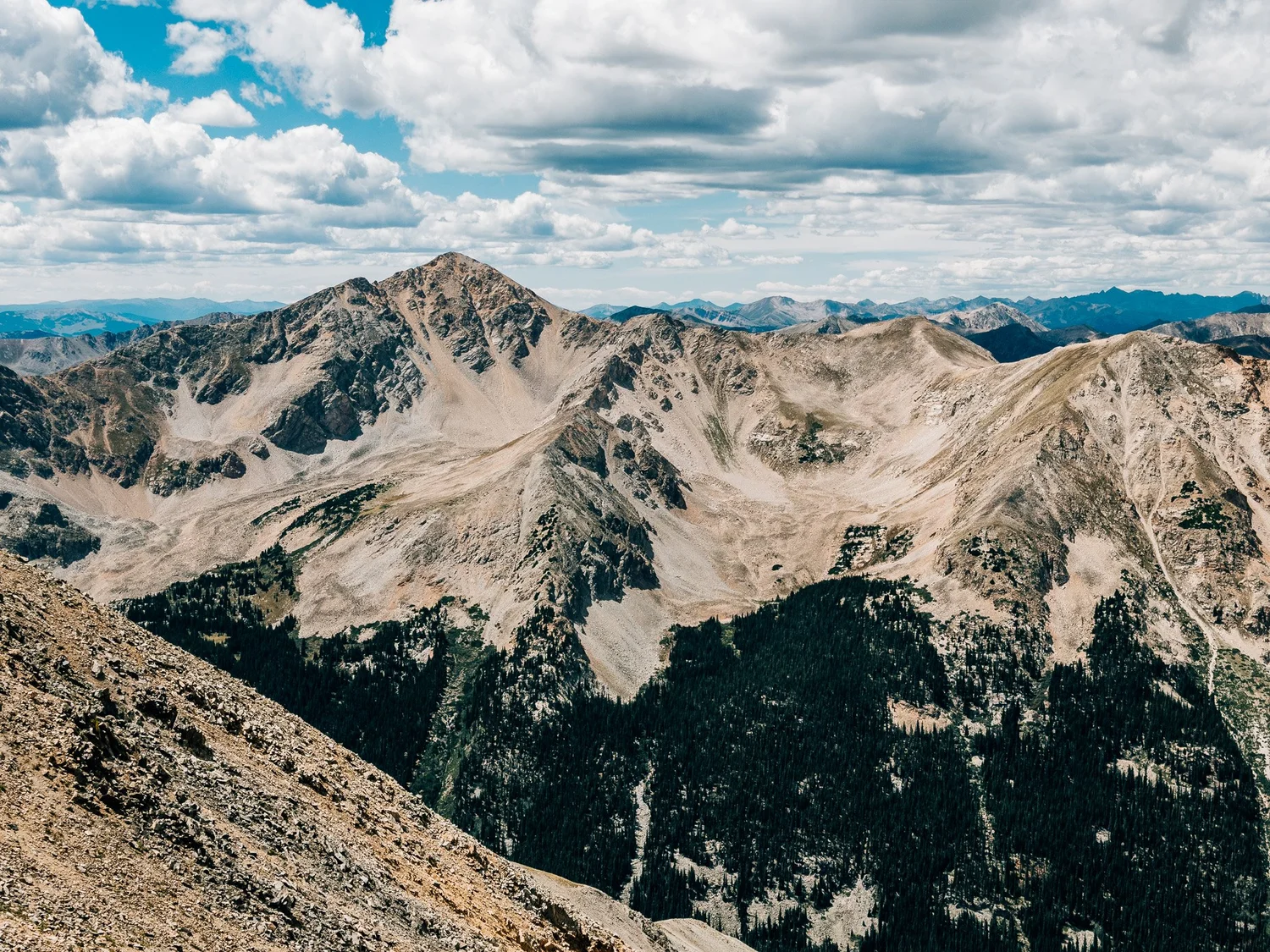 Huron Peak rising above a forested valley, seen west from the saddle on Missouri Mountain
