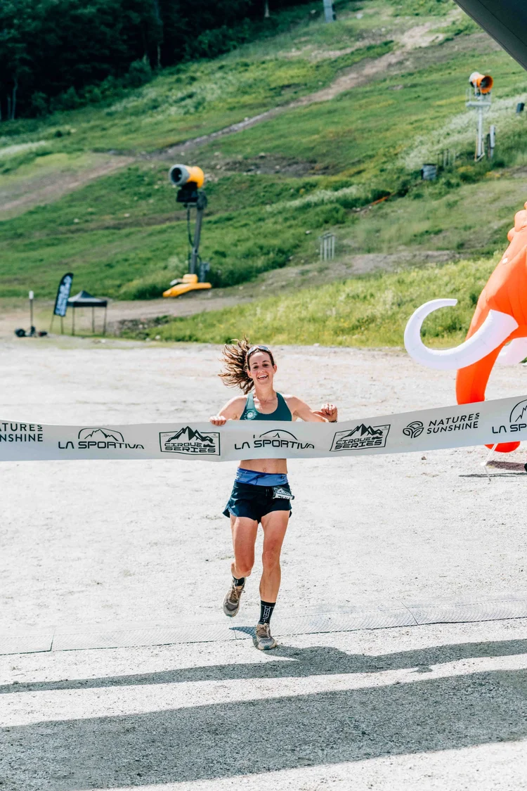Cirque Series racer breaking the finish-line tape at Killington