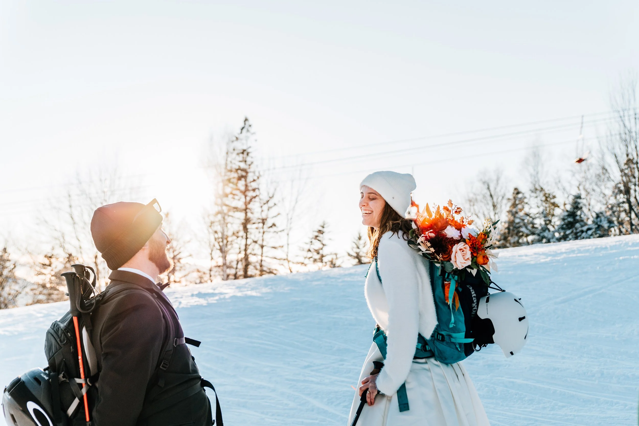 Couple hiking through snow on their elopement day