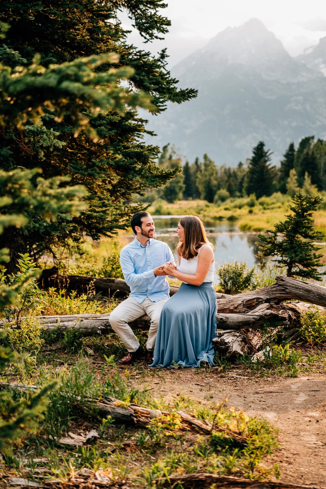 Couple laughing together near a mountain lake in Grand Teton National Park