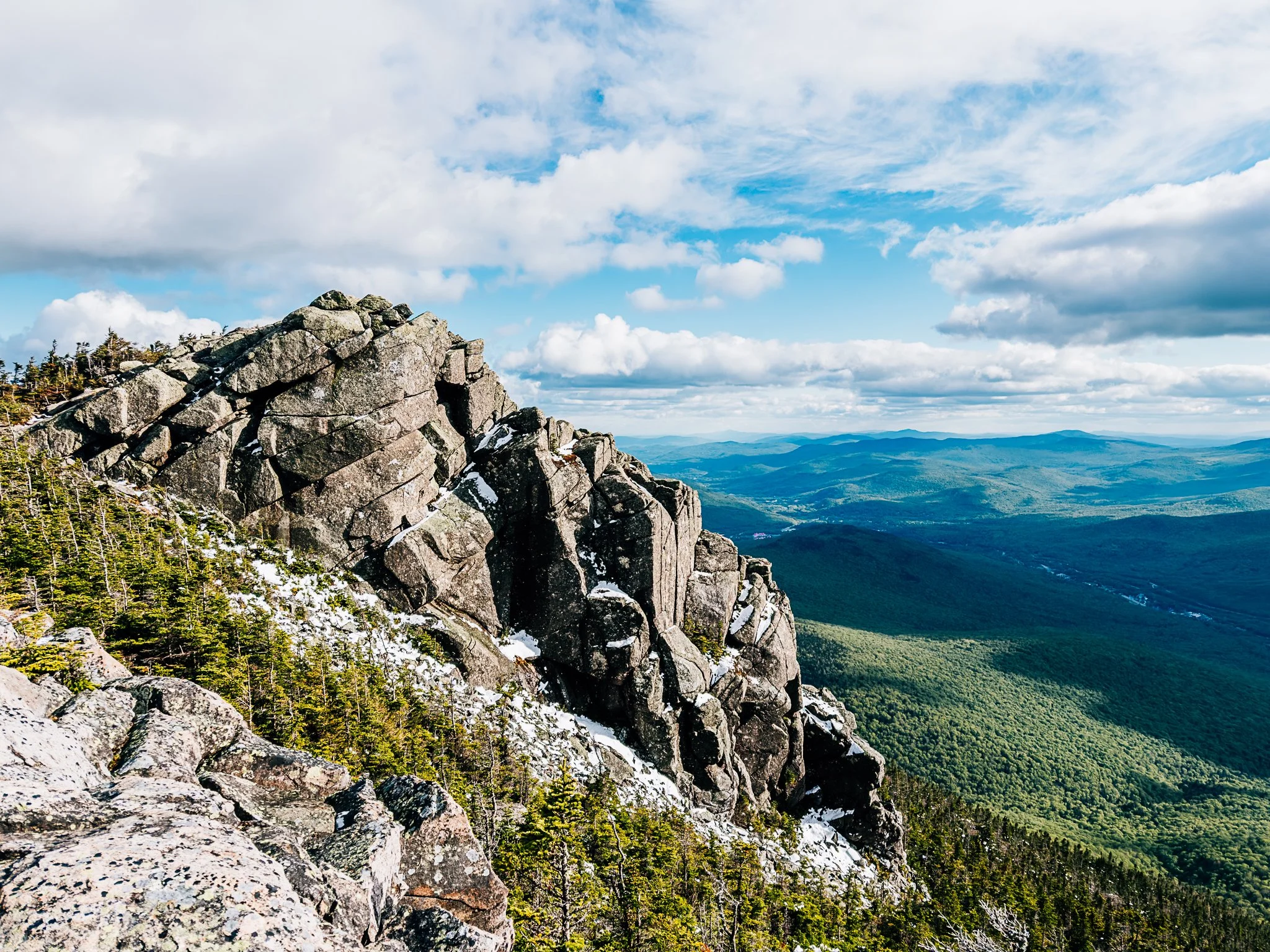 A granite outcrop above forested valleys along the Franconia Ridge near Mount Liberty