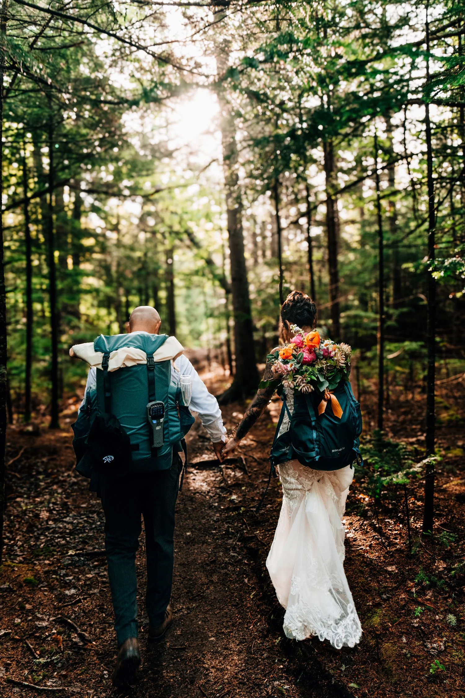 Couple hiking through a forest on their elopement day
