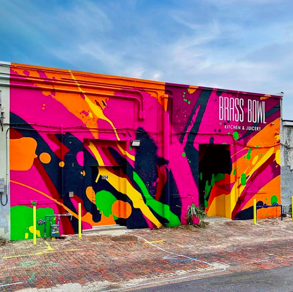 Local Muralists Tes One and the Vitale Bros painted a mural behind Brass Bowl depicting an abstract interpretation of an Acai Bowl