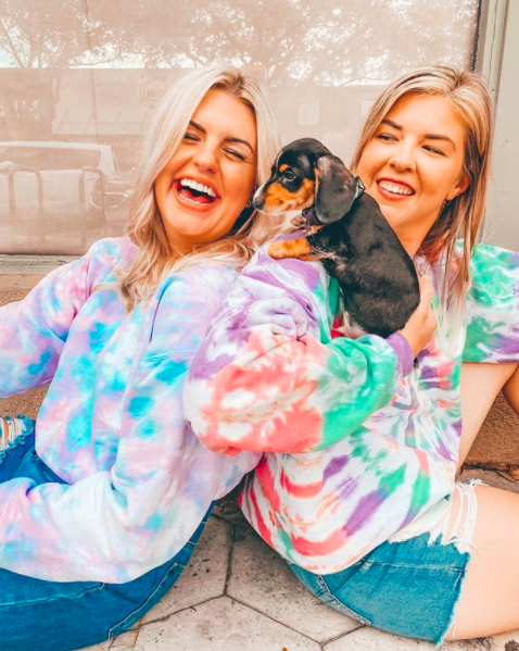 Kylie Weaver and Chelsea Nicolai showing off sweatshirts from Tupy Shop, available exclusively at Shoreline Sugars along with scrunchies and masks.