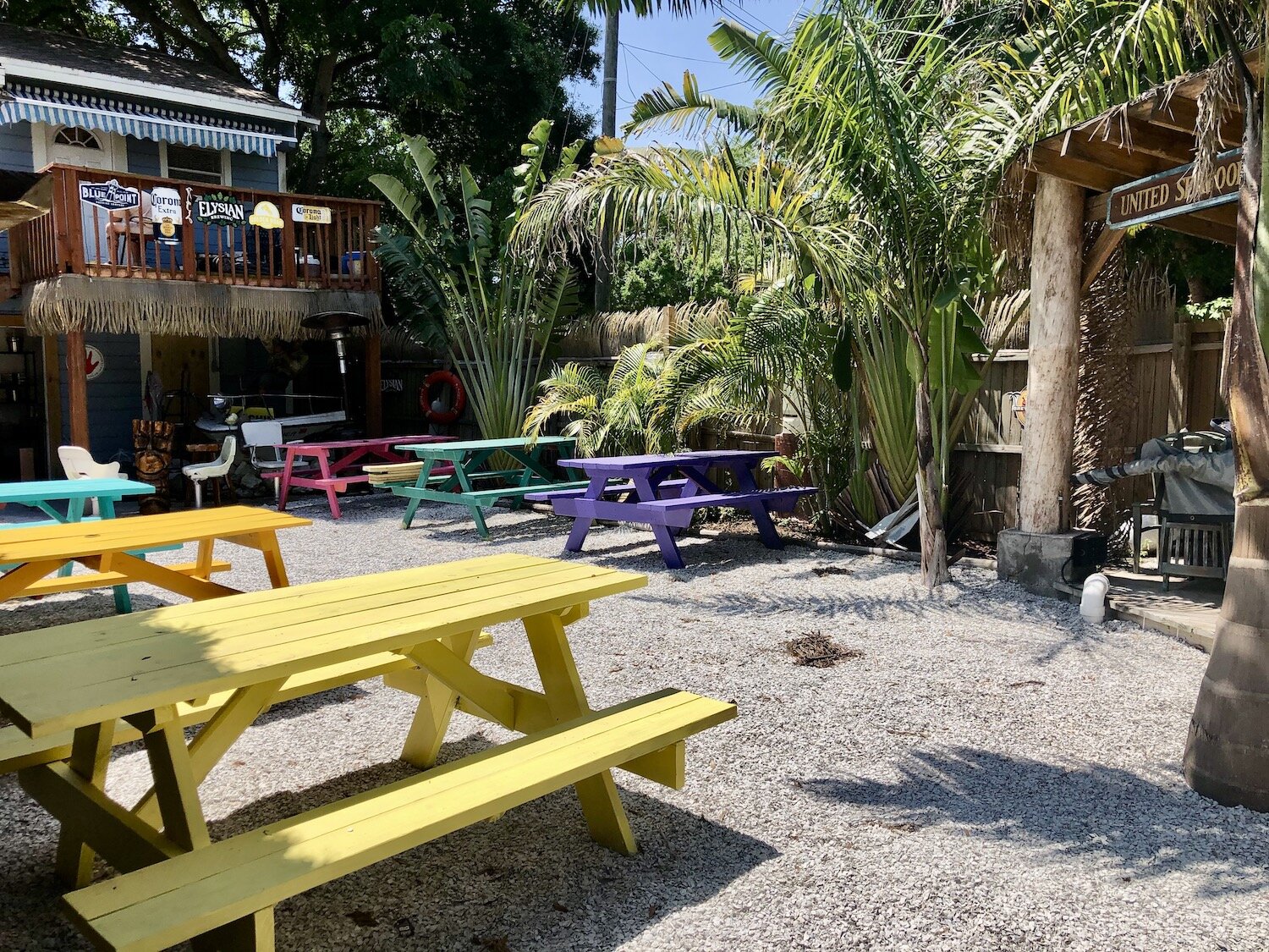 The restaurant’s expansive backyard has a full bar, picnic benches, a tiki hut, high-top table seating, and a small stage for live music
