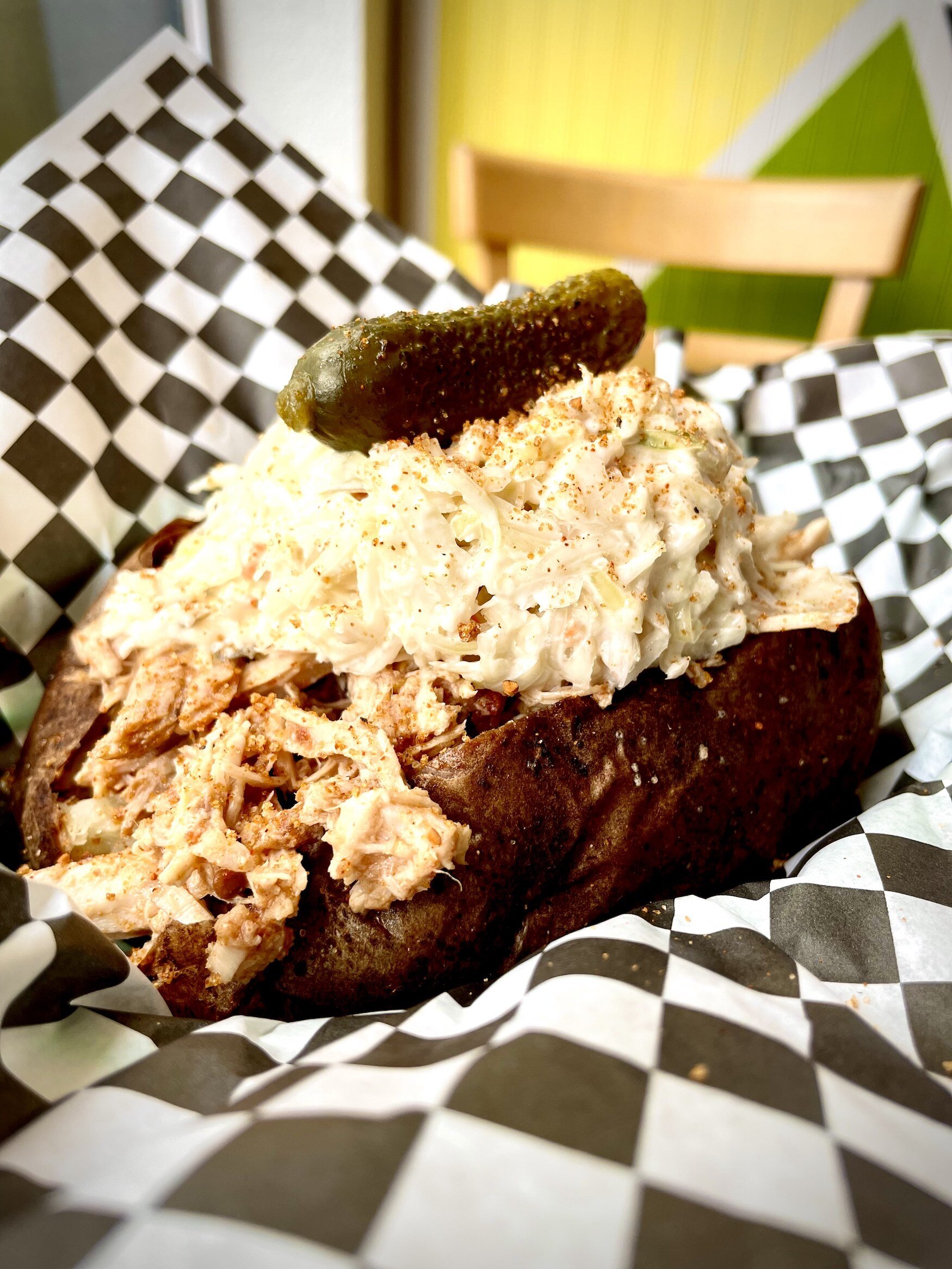 The Memphis Pork Potato topped with Memphis-style pulled pork, coleslaw, a pickle, and house seasoning