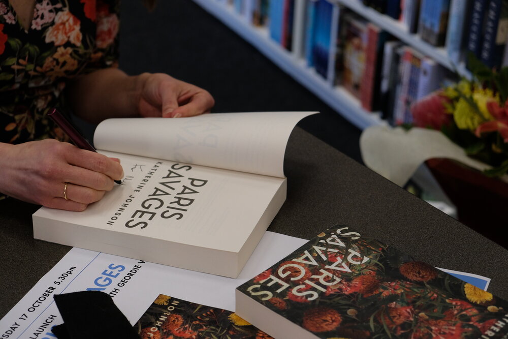 Katherine signing copies of Paris Savages for happy customers