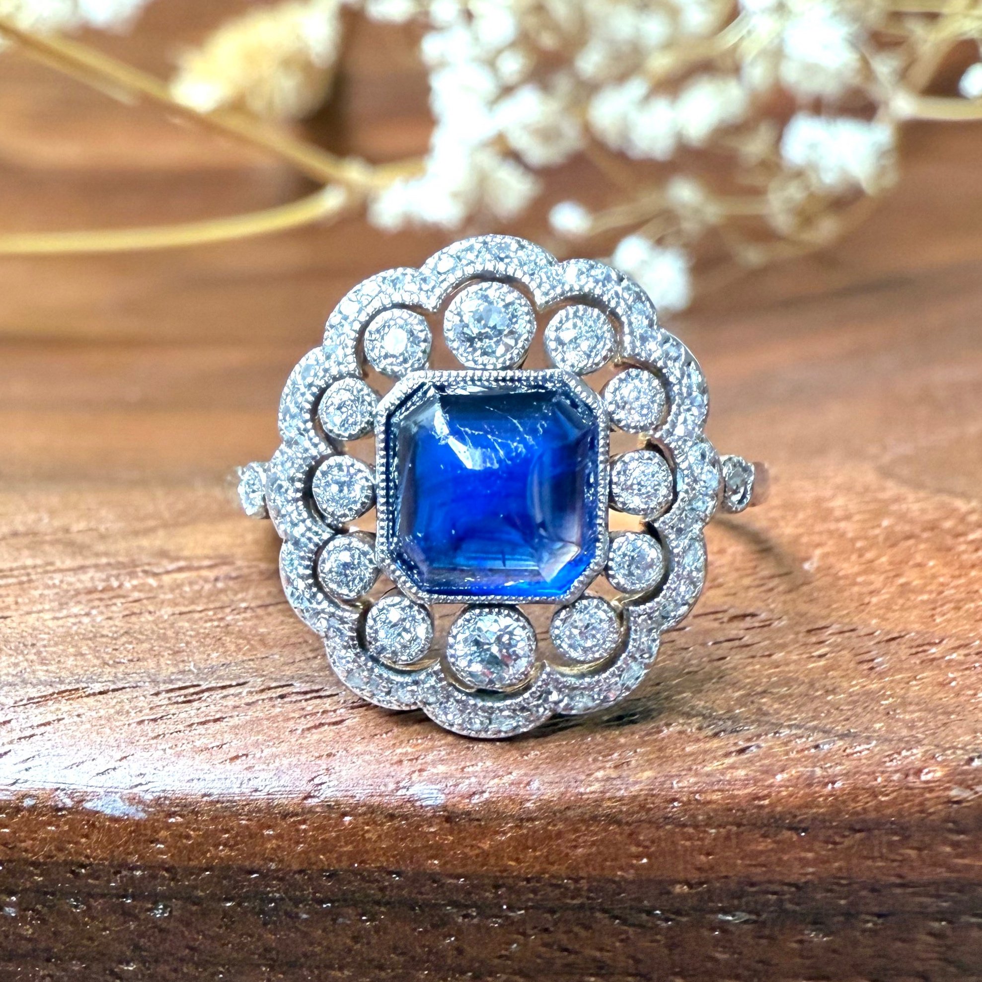 "L'Opéra" Ravissante bague ancienne circa 1900 festonnée et centrée d'un saphir taille pain de sucre