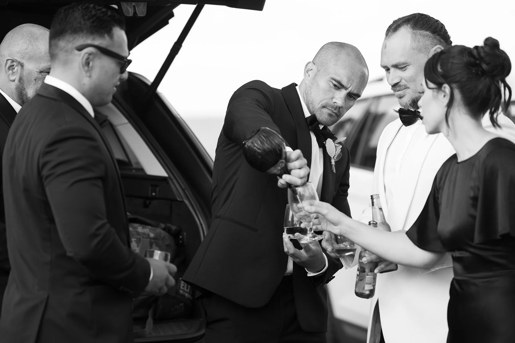 man-in-tuxedo-pours-drink-at-hygge-clifton-bay-wedding