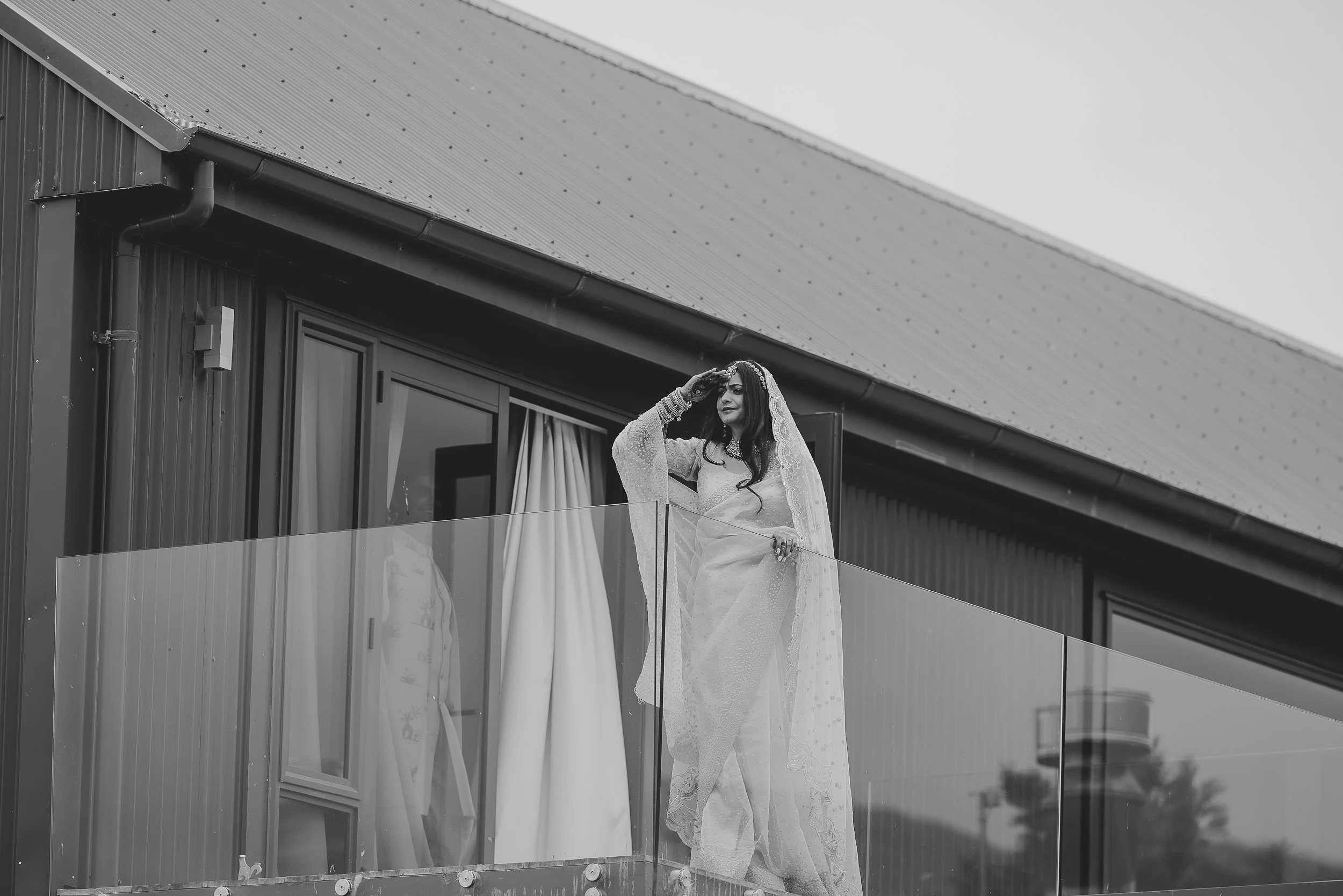 Indian-bride-looks-from-balcony-towards-the-groom-baarat