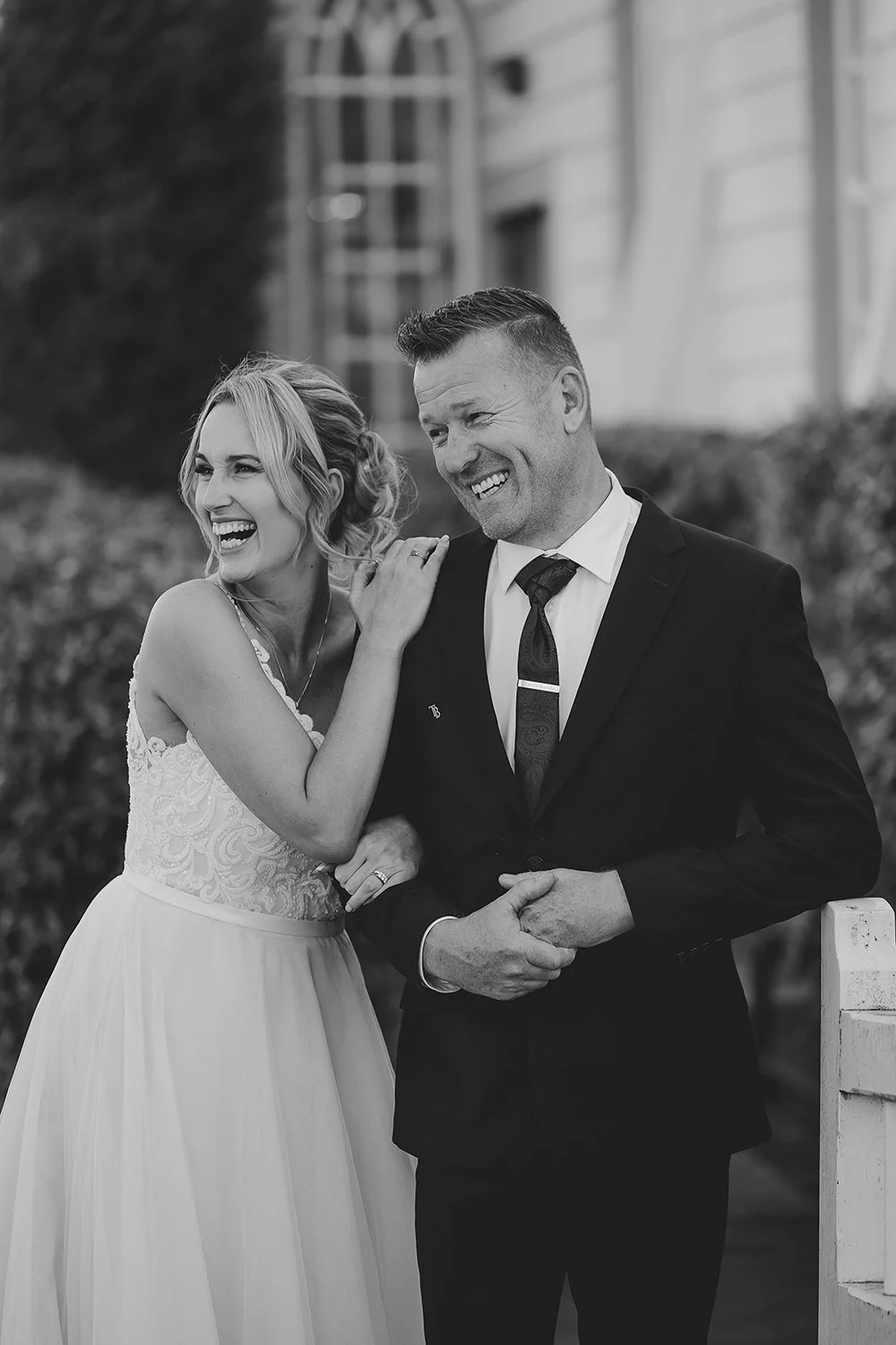 A happy couple at a Hawke's Bay wedding venue, The Old Church, smile for one of the best nz photograpahers, Eva Bradley, who took this wedding photo