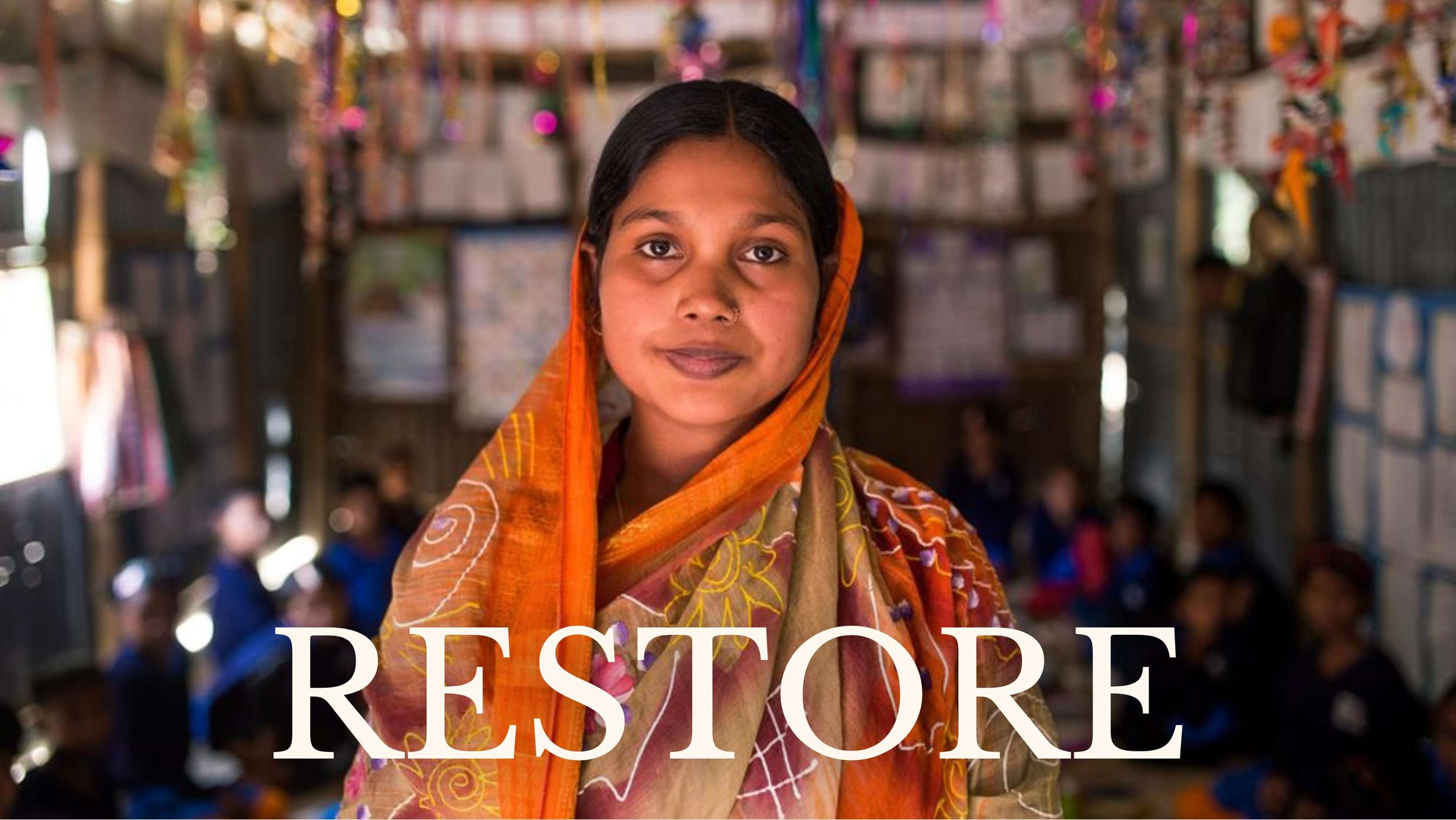 young woman in orange and yellow head scarf looks at camera, restoration human trafficking project