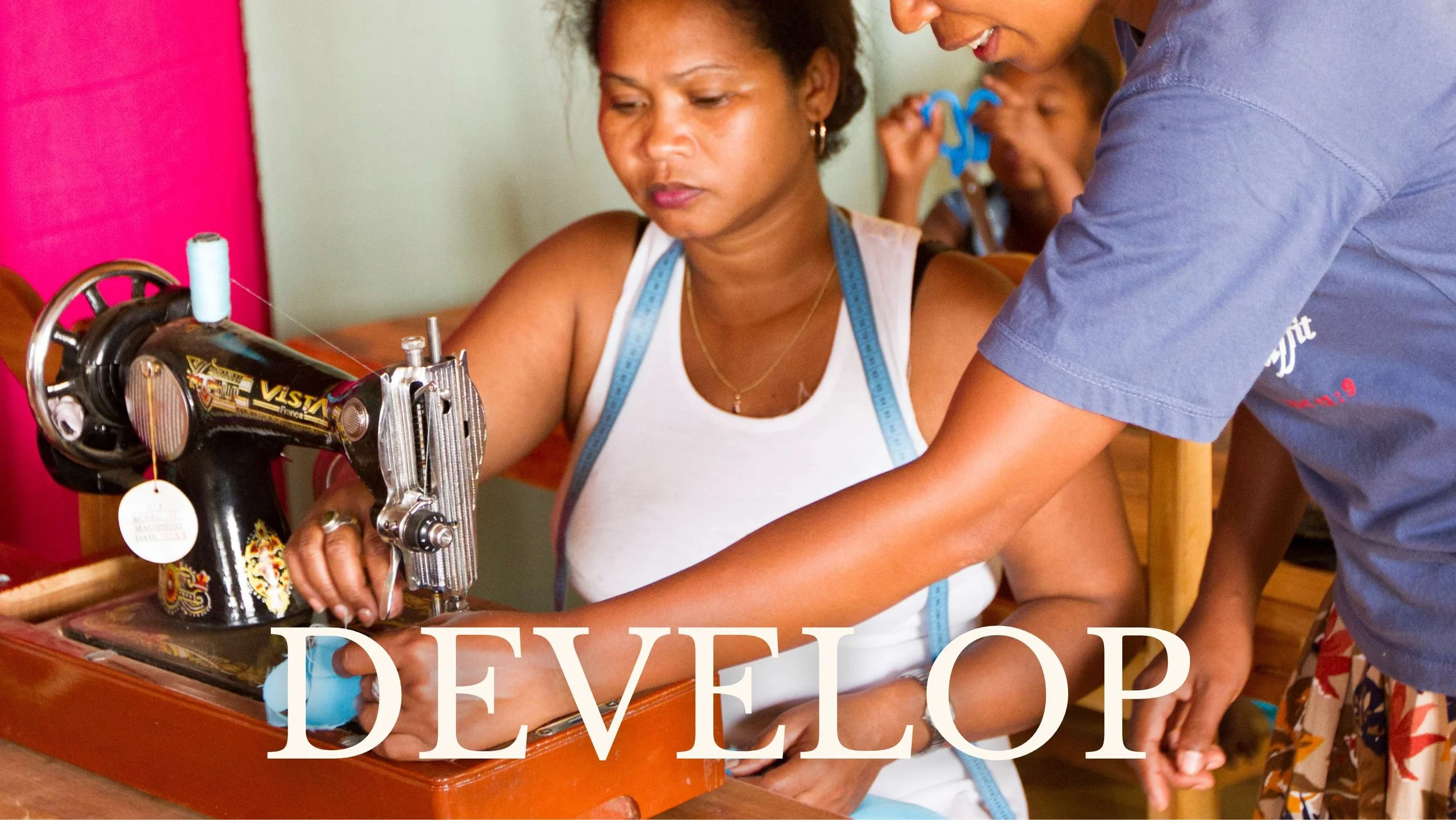 woman sits at old-style sewing machine while woman leans over to teach her, develop human trafficking project