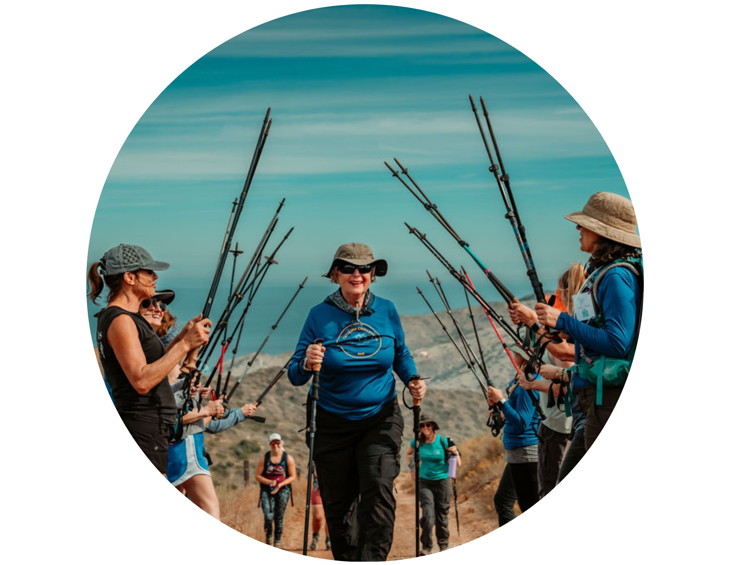 older woman in hiking gear hikes through tunnel of women lifting up hiking poles, hiking with Freedom Challenge to fight human trafficking