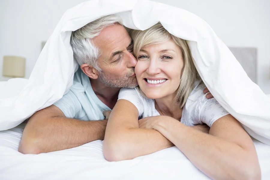 iStock_closeup-of-mature-man-kissing-womans-cheek-in-bed_58711278_small.jpg