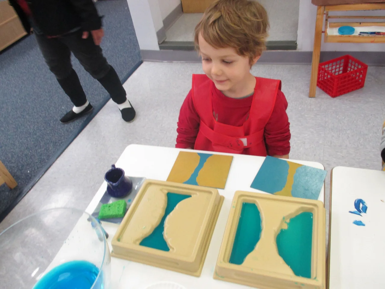 As a part of their study of land and water forms, the
Primary 1 Kindergartners took a closer look at ‘strait’ and 'isthmus’. They poured water into the strait and isthmus
trays and also used modeling clay on a paper plate to recreate these two land
and water forms.