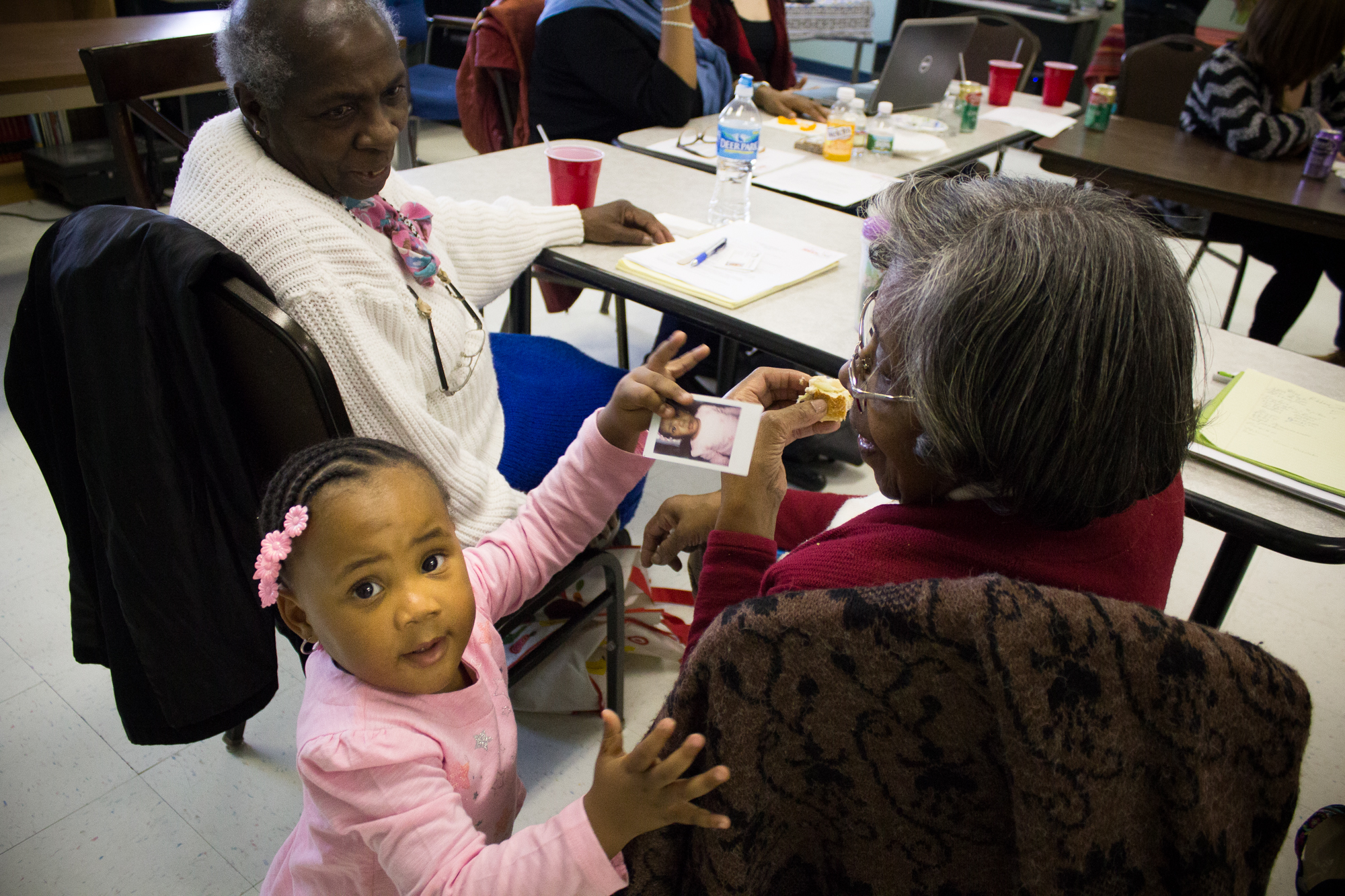  Malayja Tooles, 2, shows a photo of herself to Mary Bell, 83,&nbsp;during The Redline Project workshop at The Dixon House in Point Breeze January 16, 2016. 
