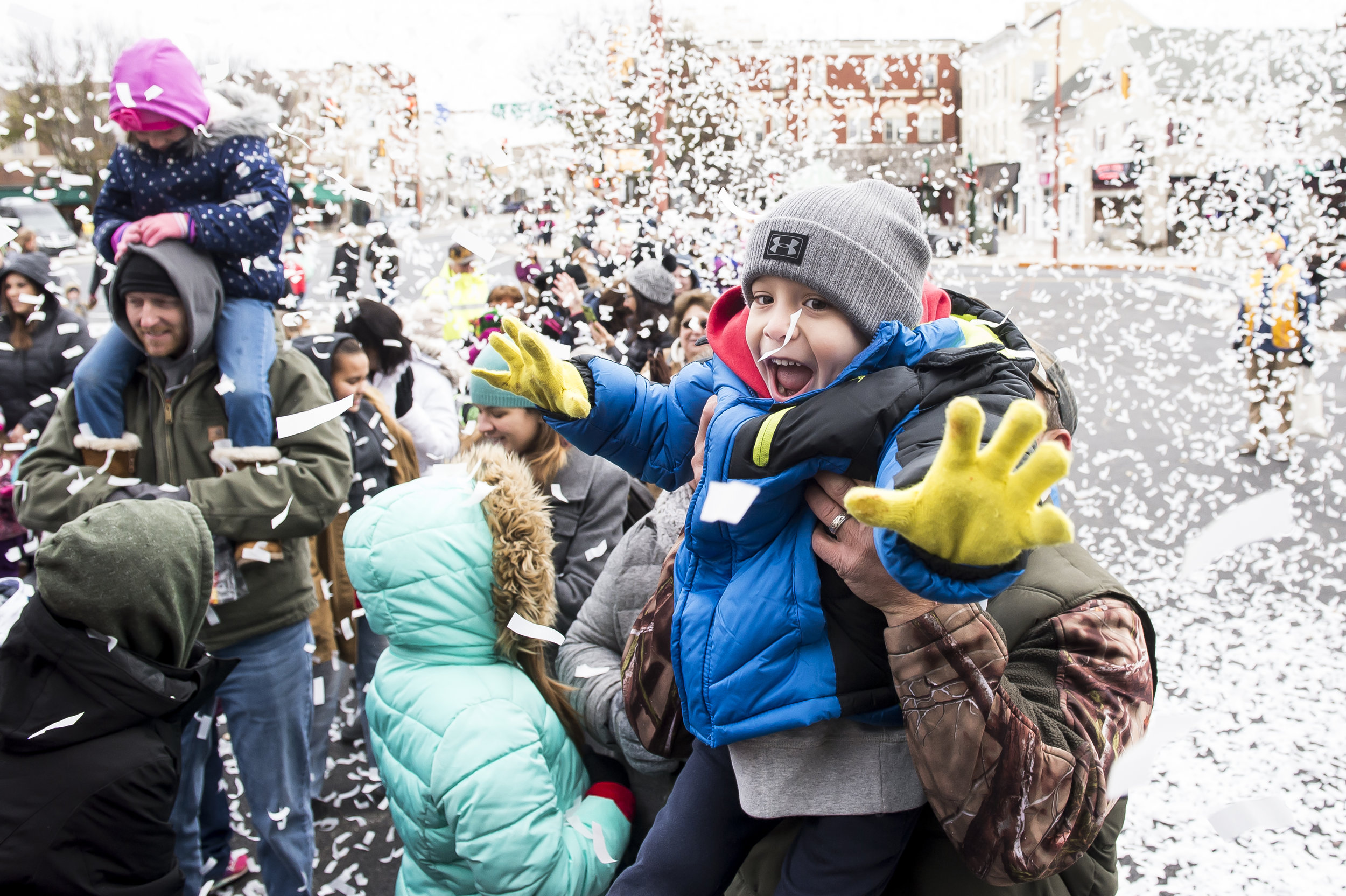  Reese Werner, 5, plays with confetti as his dad, Joe Werner, holds him up at the annual Hanover Christmas parade.  