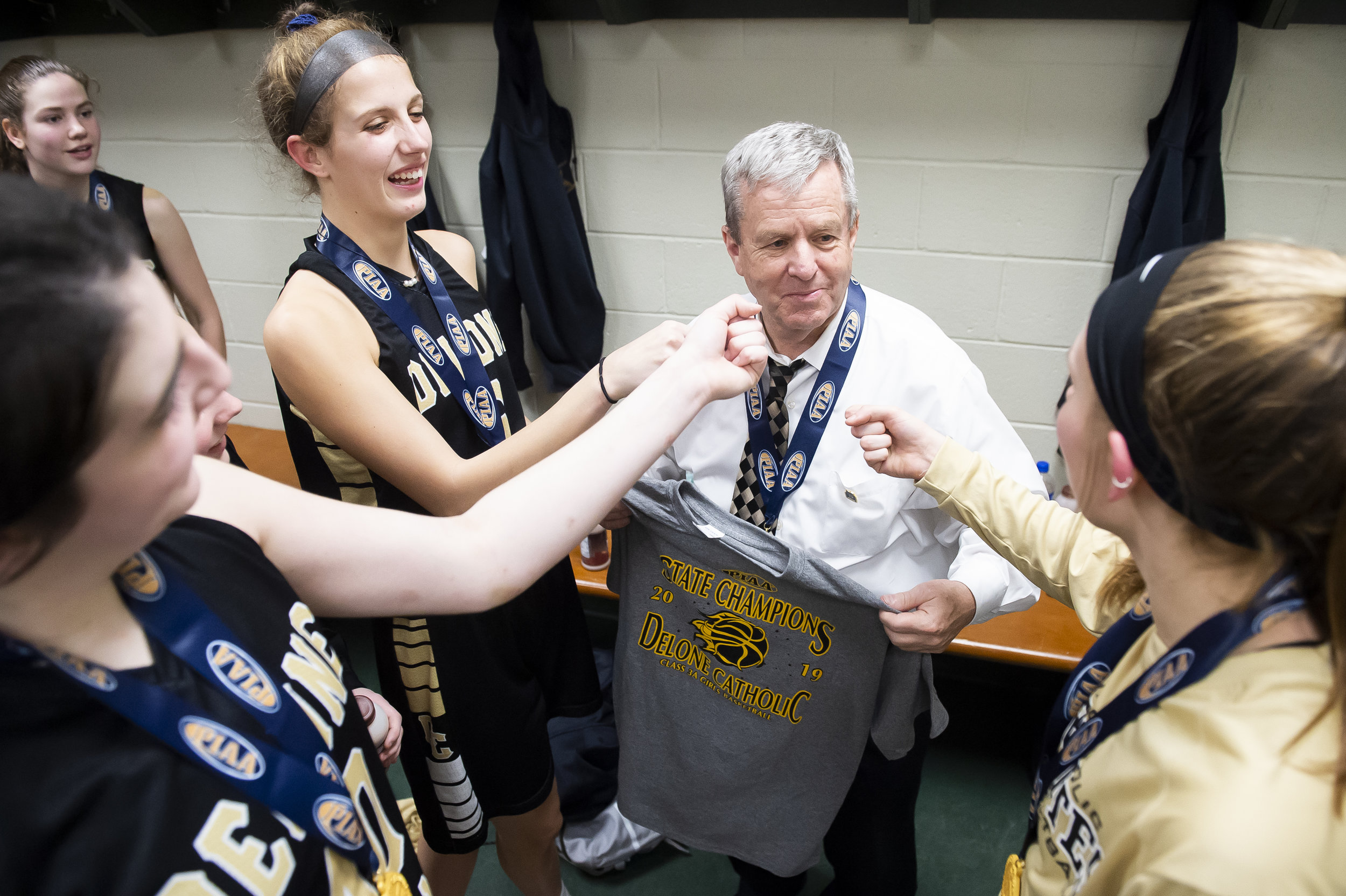  (Clockwise from far right) Delone Catholic senior starters Maggie Wells, Bradi Zumbrum and Riley Vingsen give head coach Gerry Eckenrode a mock interview in the locker room following their PIAA 3A championship win over Dunmore at the Giant Center in