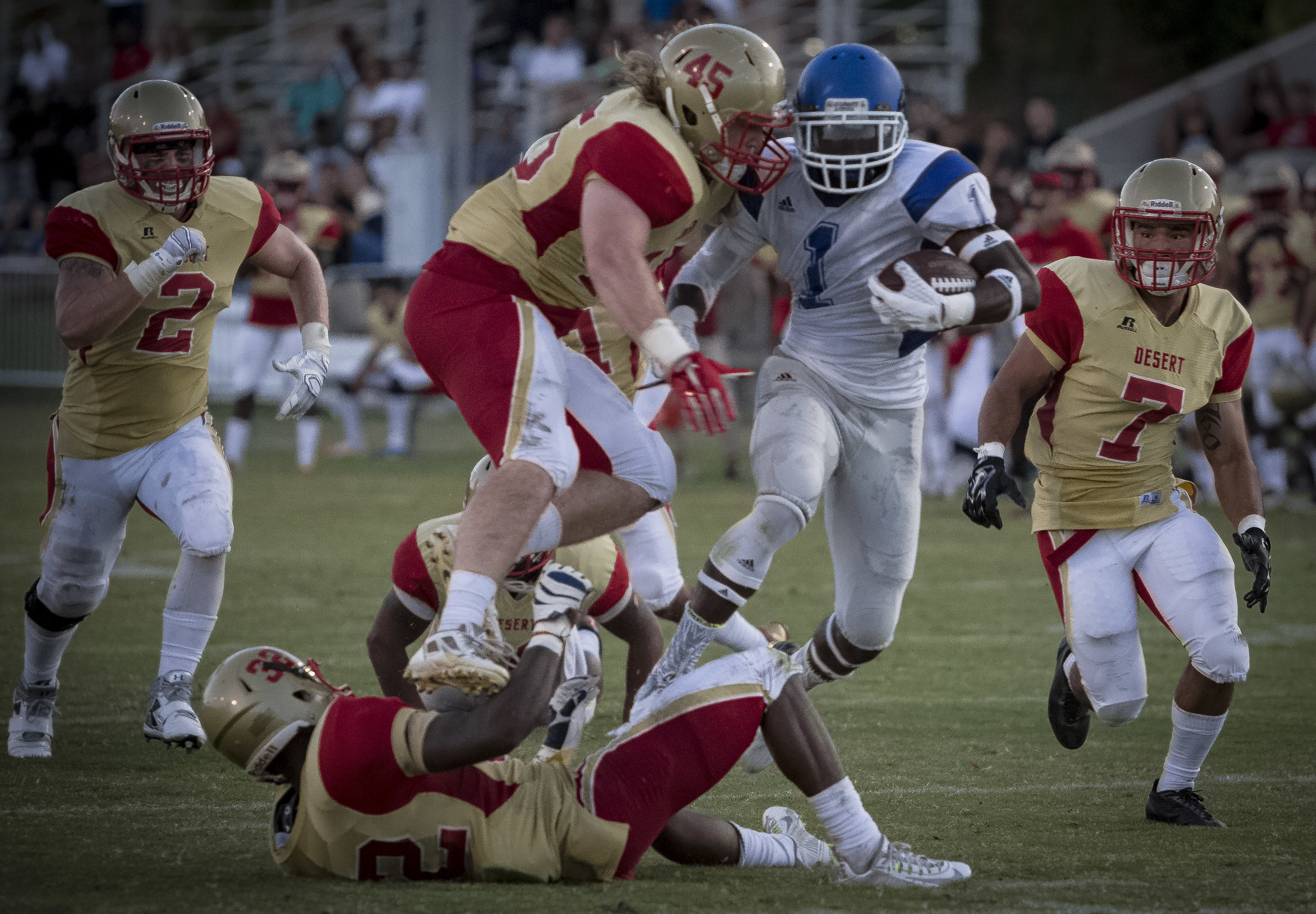  The Santa Monica College Corsairs Freshman runningback #1 Kwame Duggins (In White,Center) splits defenders linebacker #45 Chance spates (Gold,Center), and cornerback #32 T. D. Armstrong (Gold,Center) from the College of The Desert Roadrunners to sco