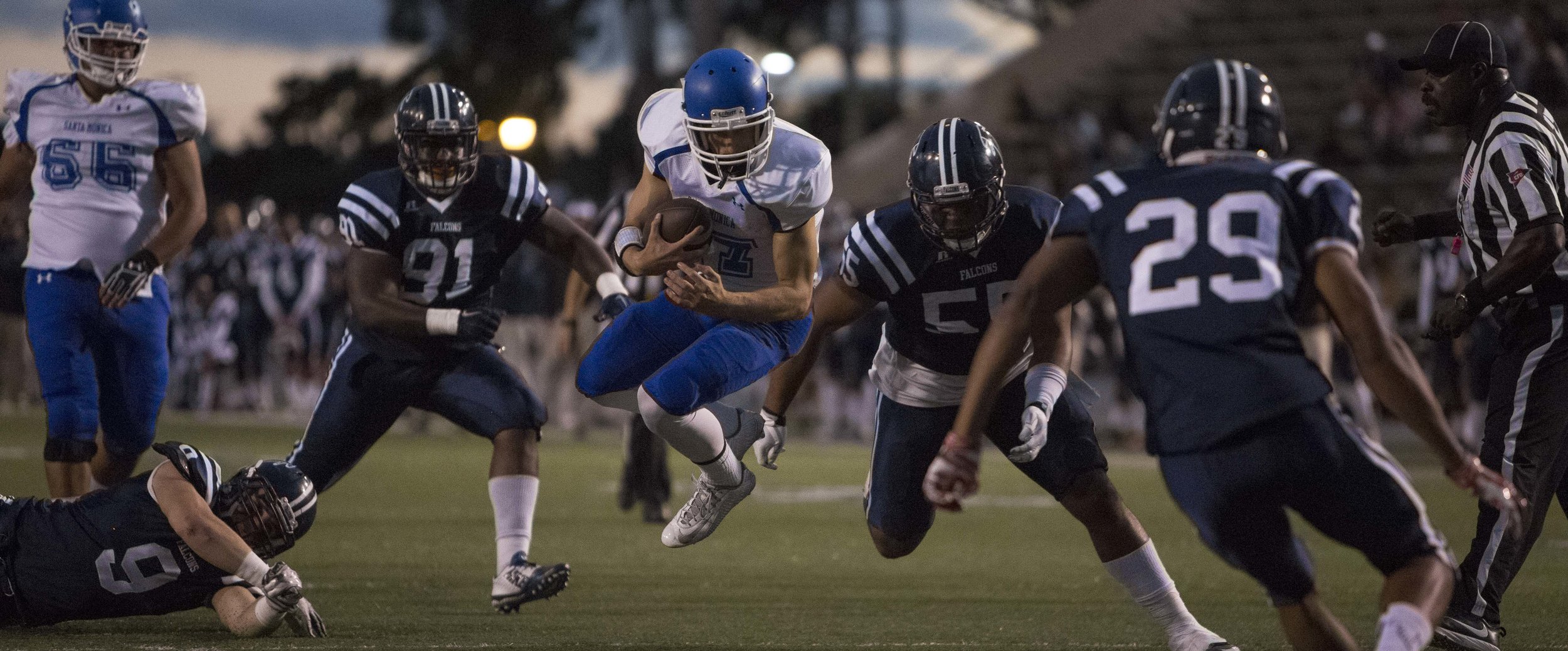  The Santa Monica College Corsair men's football team freshman quarterback #17 Weston Massett (white,center) makes a huge dive for a first down against The Cerritos College Falcona away in Cerritos , Calif. on October 17th, 2016 . The Corsairs would 