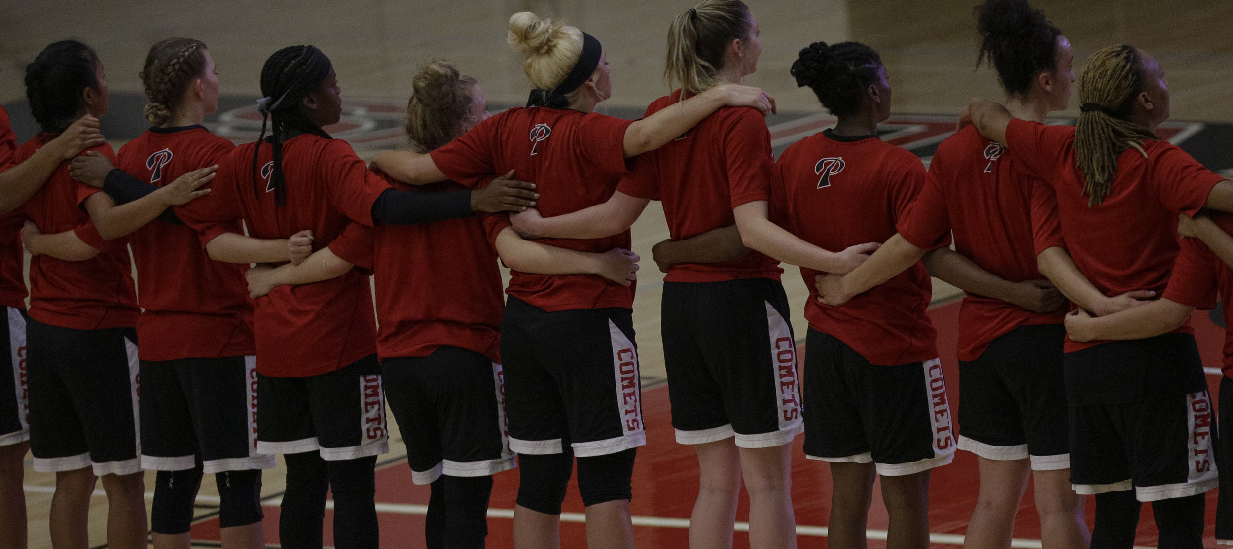  The Palomar Comets womens basketball team in arms around eachother during the national anthem before facing off against The Santa Ana College Dons . The Dons would fall to the Comets 76-61.   Photo taken October 3rd 2016 at Santa Ana College in Sant