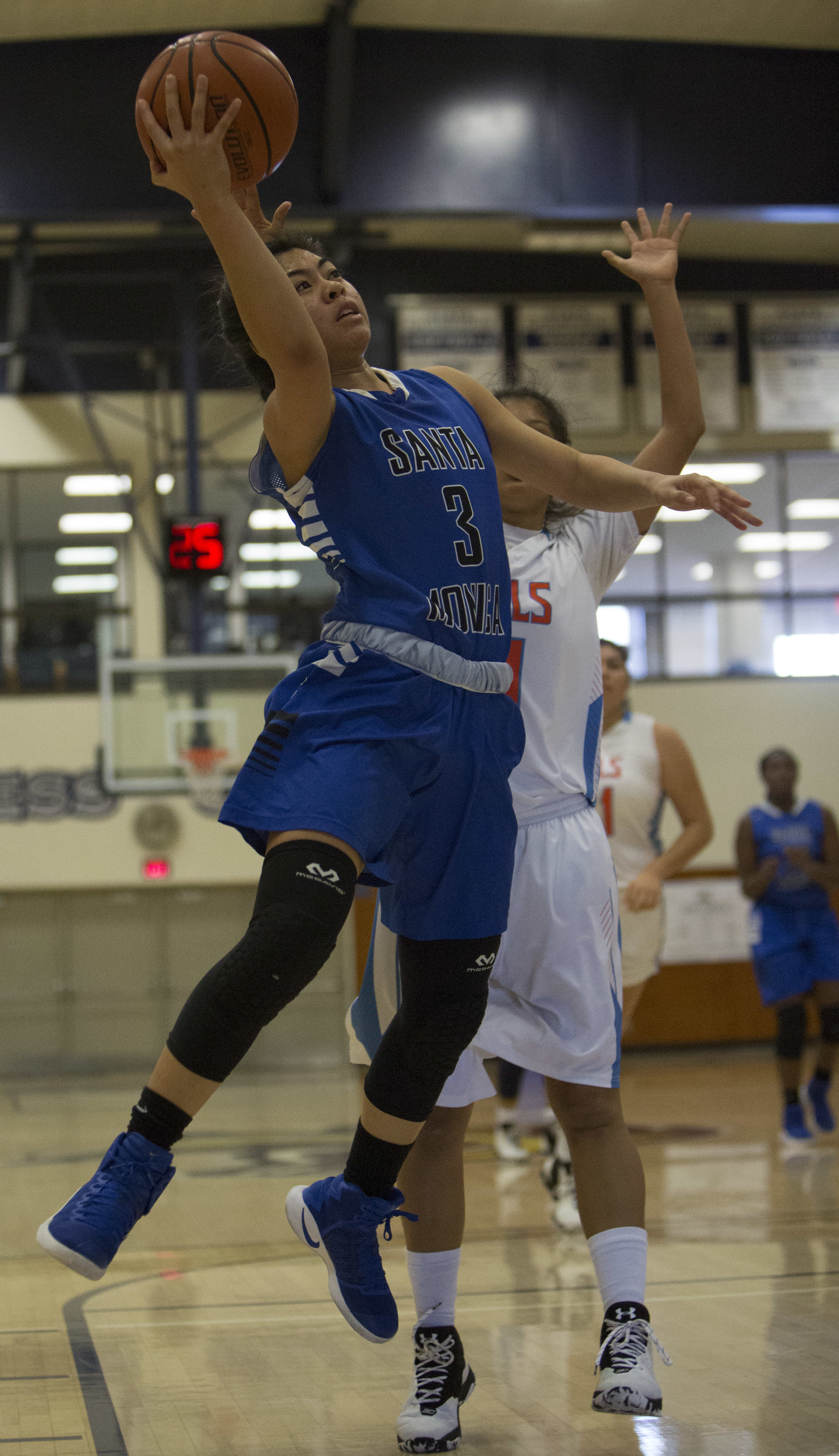  December 4th 2016. The Santa Monica College Corsair Womens Basketball team freshman point guard (3) Janet Medina (blue,right) drives past The Citrus College Owls sophomore guard (11) Jasmine Meza (white,right) to score a layup  in the 33rd annual La