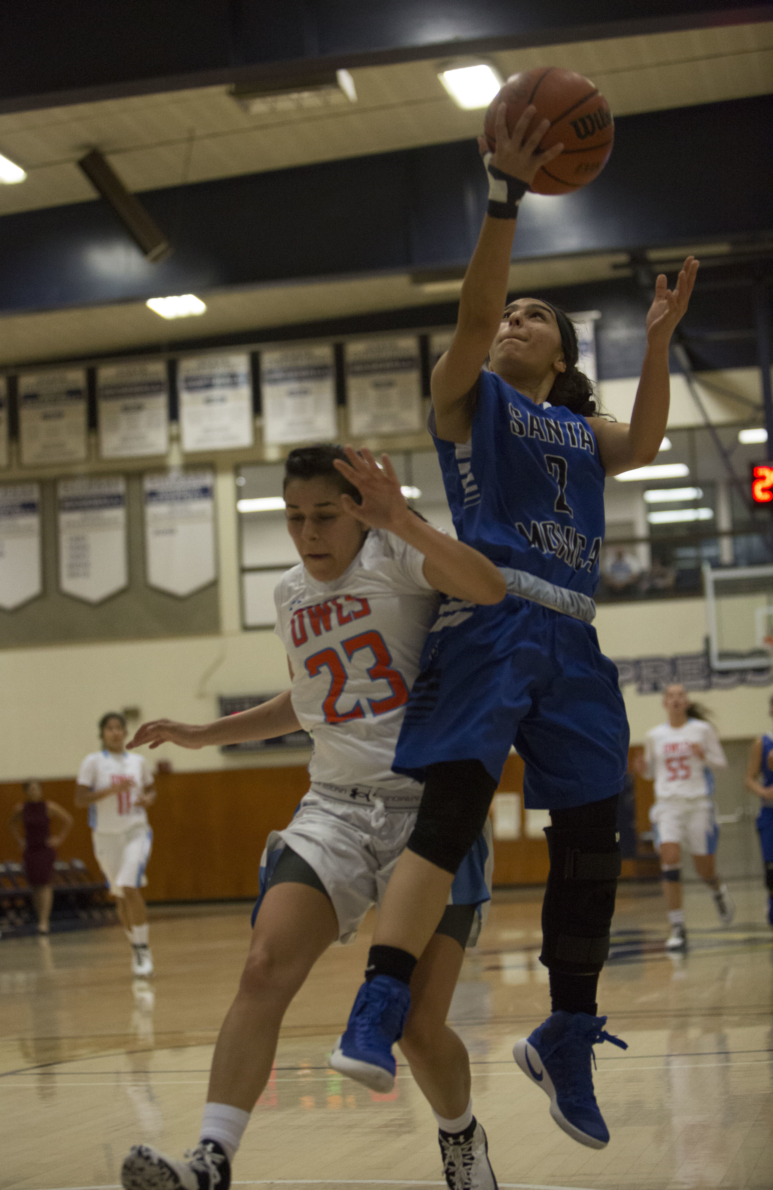  December 4th 2016. The Santa Monica College Corsair Womens Basketball team freshman guard (2) Jessica Melamed (blue,right) had an open break away but would be fouled by The Citrus College Owls freshman guard (23) Cassandra Martinez (white,left)  in 