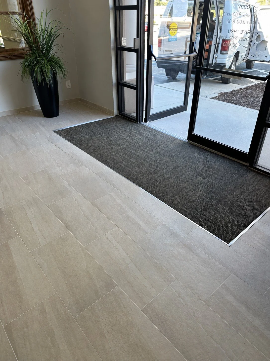 Commercial carpet tile entry inset surrounded by light tile flooring at Bank OZK in Bradenton, Florida
