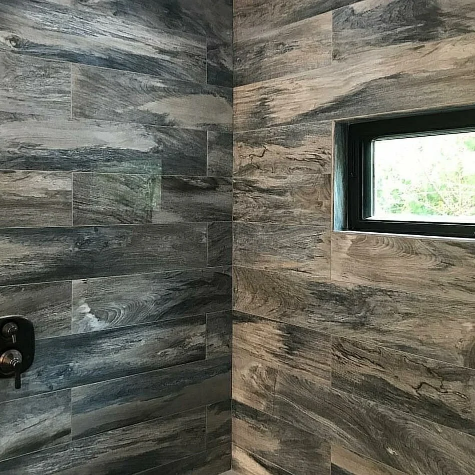 Gray and brown wood-look shower tile around a horizontal window