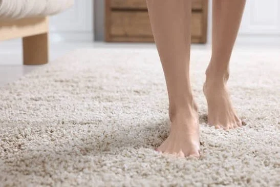 Bare feet on soft, light-colored carpet