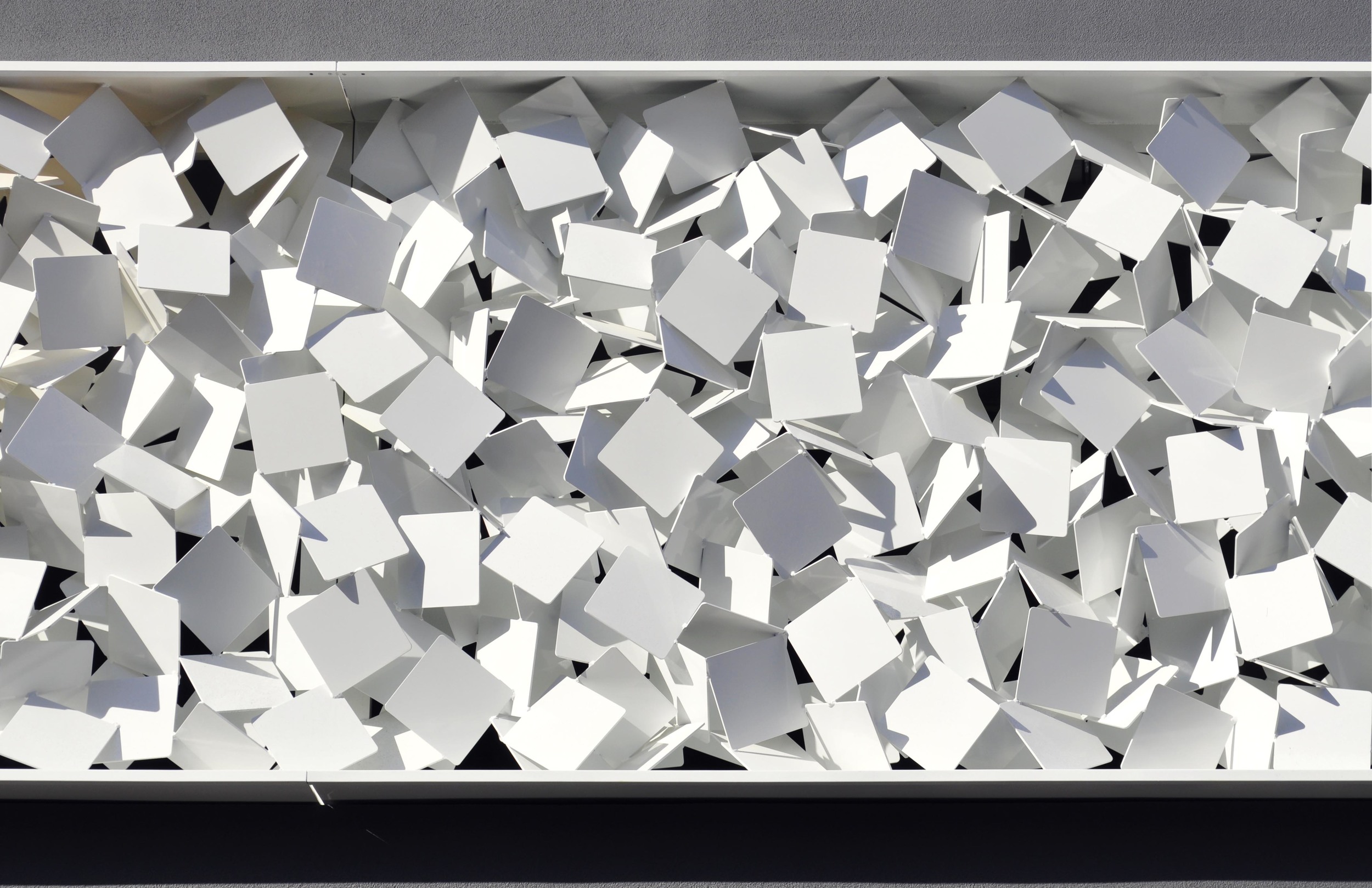  This Public Artwork in Perth titled   Transpiration   and is made up of thousands of aluminium squares that are arranged in an agitated assembly of chaotic energy. The artwork also acts as a visually permeable screen to the carpark behind and is enl