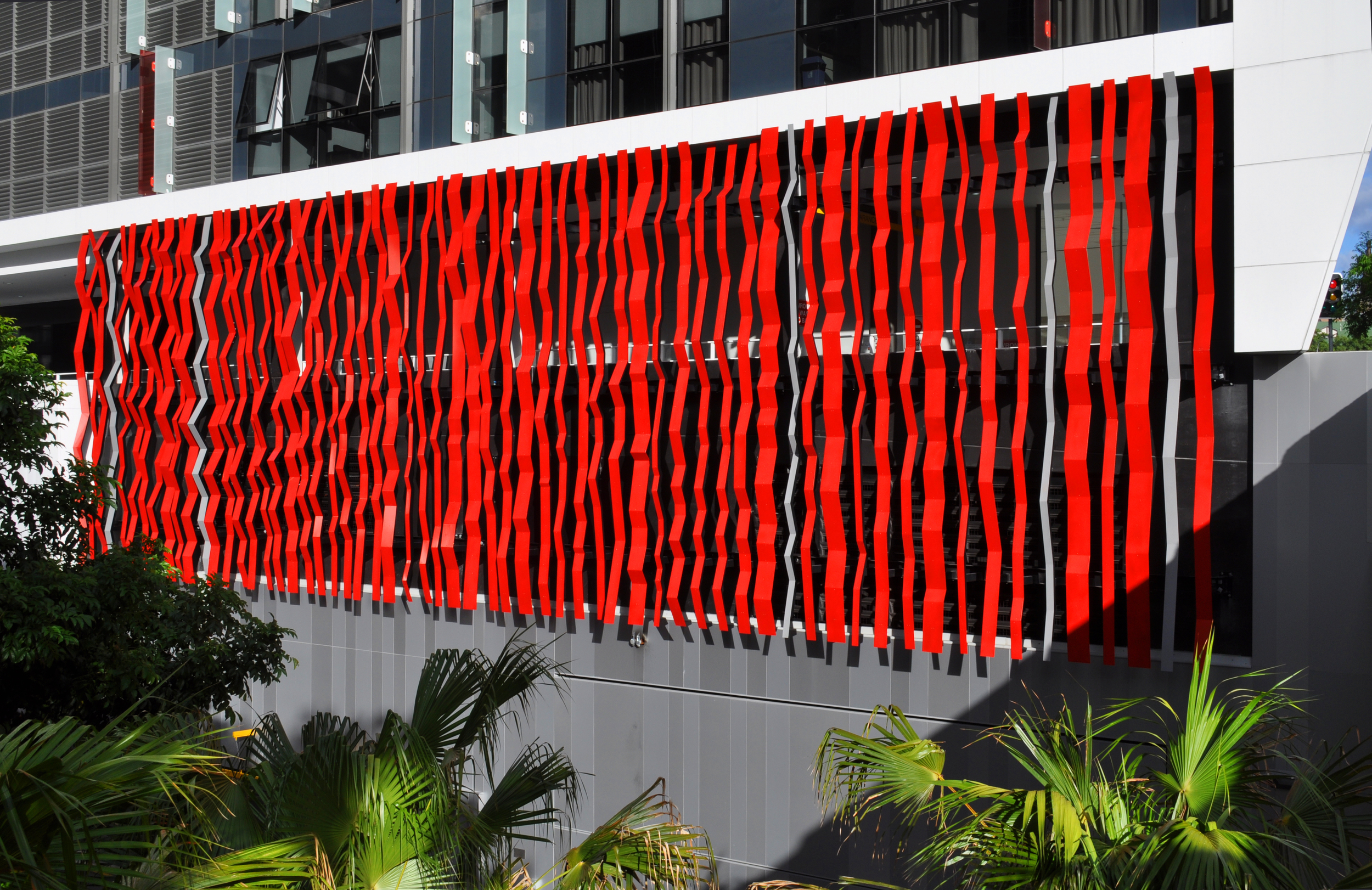  Flux is a façade based public artwork for the Soleil building in Brisbane and forms a visually dynamic screen allowing ventilation to the building behind. The work evokes the dynamics of water flow and eddies with references to the shadows of tall r