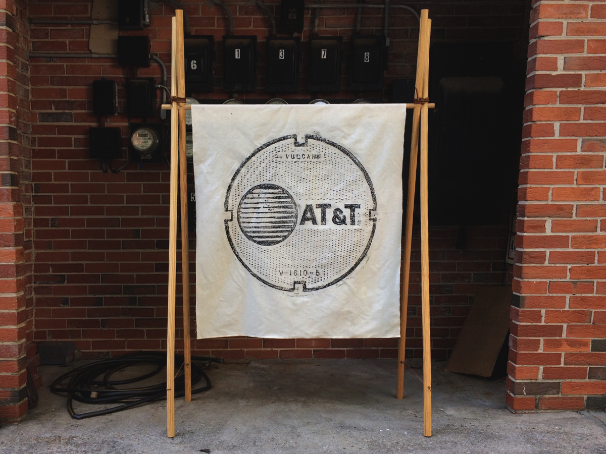 AT&T - Size 37.6"x45" (100% Cotton) - Wax Rubbing of a manhole cover - Print size 28"x28" - Three 1/2" gold metal grommets
