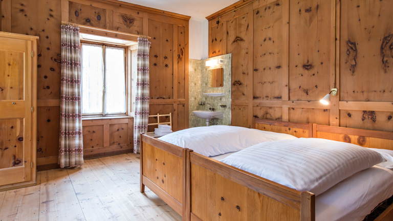 Room at Albergo Della Posta. Classic, spacious timber paneled rooms with private sink. S hower and toilet facilities are shared. Single room: CHF 950 Double room: CHF 850