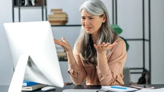 woman looking frustrated at computer indicating the myth that AI is inherently unhealthy to use as a relational tool.