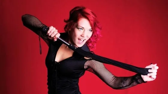 woman with flogger indicating the stereotype for Kink.